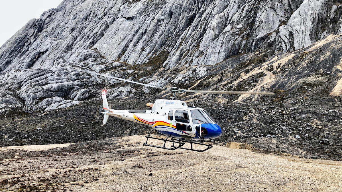 Climbing Puncak Jaya: How To Summit Carstensz Pyramid | helicopter Puncak Jaya A helicopter lands on Puncak Jaya mountain in West Papua, Indonesia on the island of Guinea.