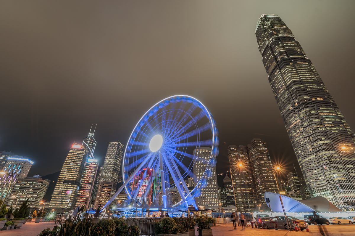 The Ultimate Hong Kong Bucket List: 25 Best Things To Do! | hong kong observation wheel A lit-up Ferriss Wheel at night in Hong Kong