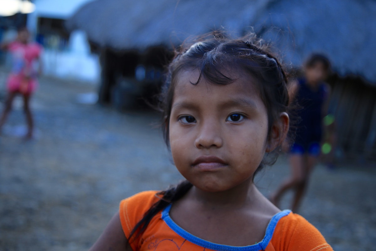 San Blas Islands Travel Guide: Best Things To Do & Logistics | kuna people san blas islands A young girl in an orange top portrait photo.