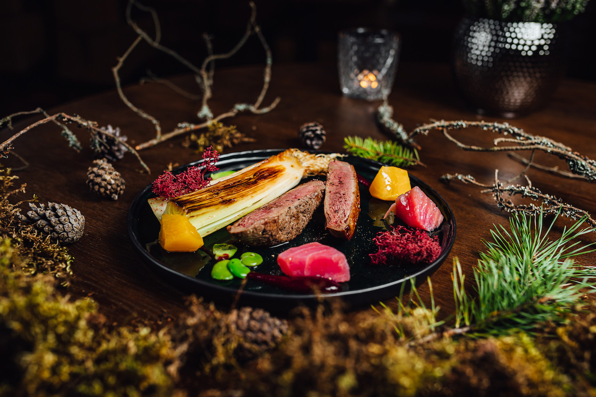 Cost of Living in Bangkok (& The Lies That Bloggers Tell) | luxury dining Fresh duck meat steak in Michelin star restaurant. Food table with forest decorations. Michelin food