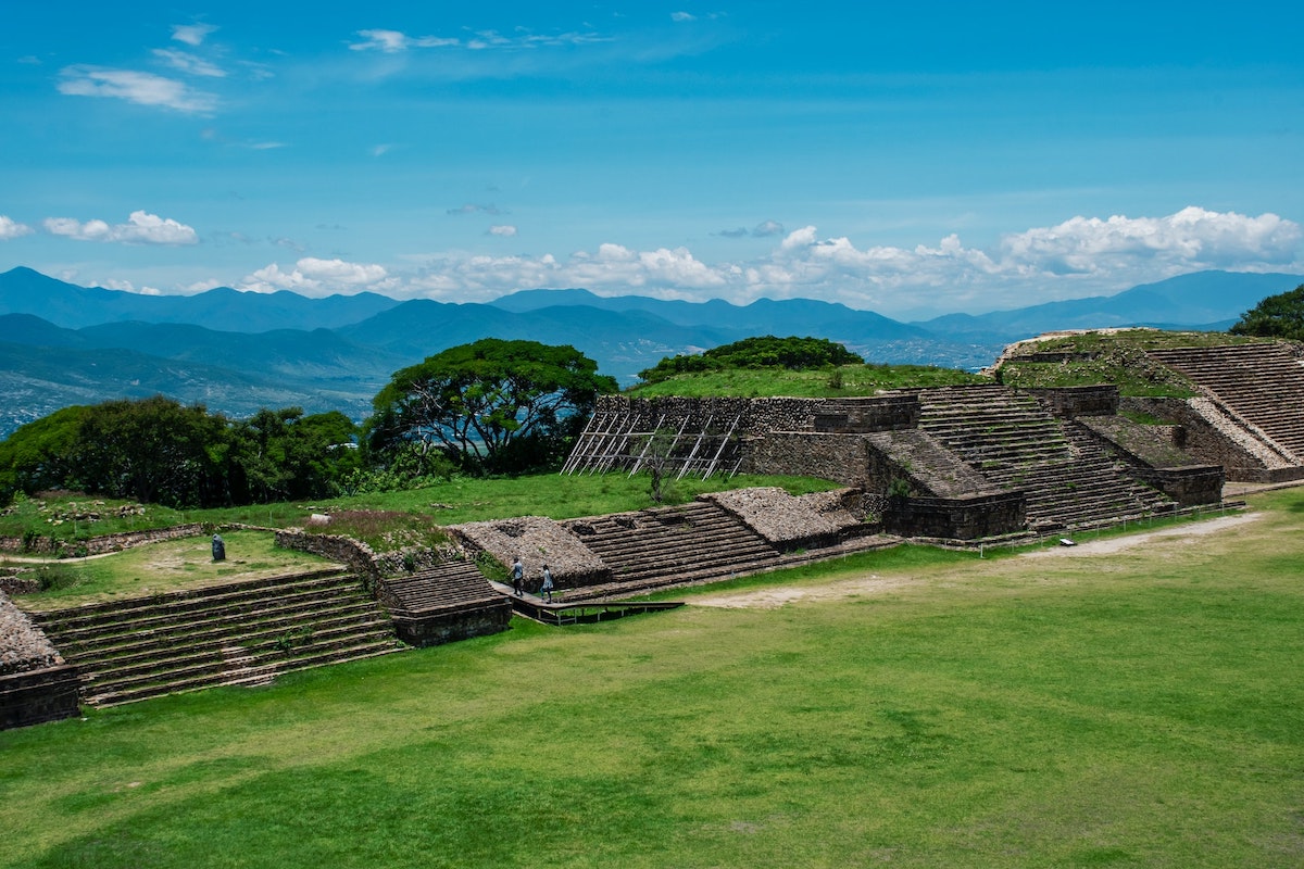 16 Famous Landmarks in Mexico (& How To See Them in 2024!) | monte alban Ancient steps from a leftover building overlooking mountains.