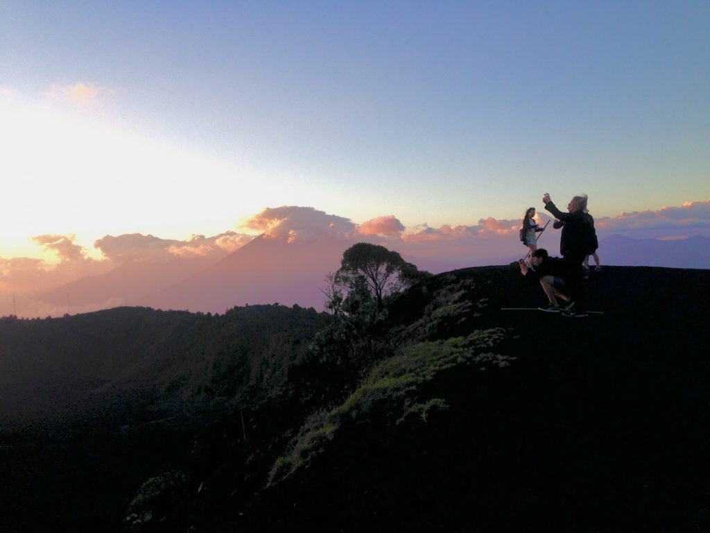 Pacaya Volcano Sunset Hike: An Honest Guide For 2024 | pacaya volcano sunset hike Tourists take photos at sunset at the summit of a volcano in Pacaya, Guatemala.