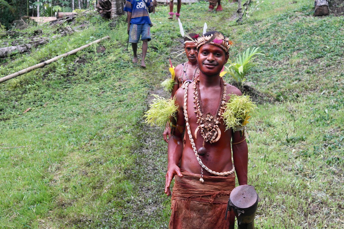 The Tribespeople of Papua New Guinea: A Detailed Guide | papua new guinea tribesmen smiling Two tribesman smile as they walk in the Papua New Guinea rainforest