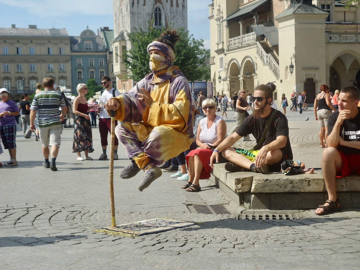 Visiting Auschwitz: All You Need To Know & What To Expect | street performance Krakow A levitating illusionist performs in the streets of Krakow