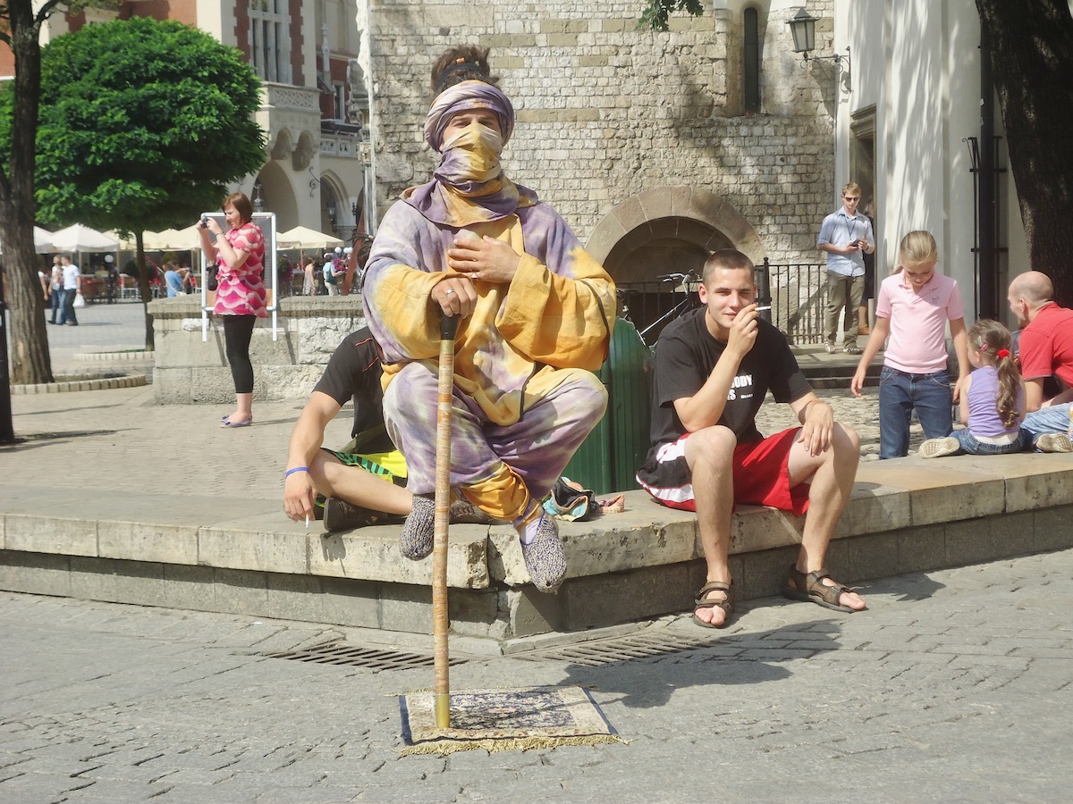 Visiting Auschwitz: All You Need To Know & What To Expect | street performer Krakow A street performer with a wrapped up face levitates in Krakow, Poland