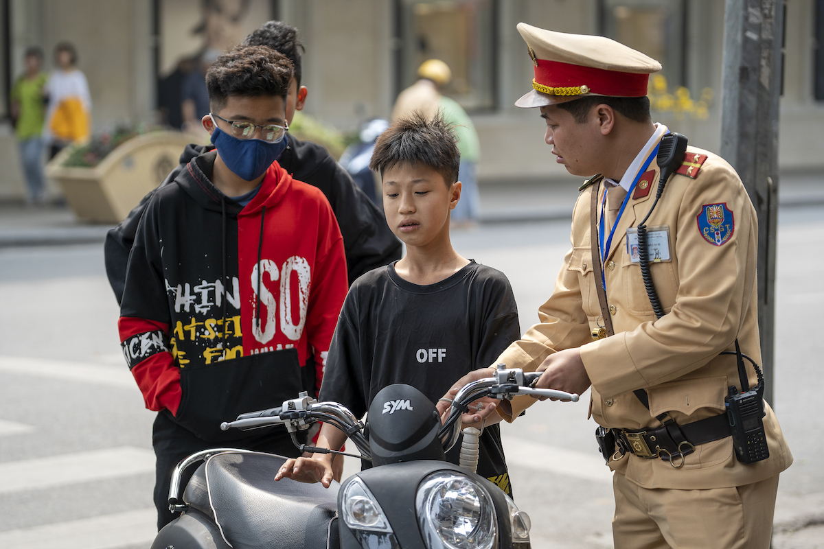 Driving A Motorbike in Vietnam: Tips & Detailed 2024 Guide | vietnam motorcycle policeman A Vietnamese police officer stopped a motorbike driver boy for violating traffic rules on the street in the old town of Hanoi, Vietnam